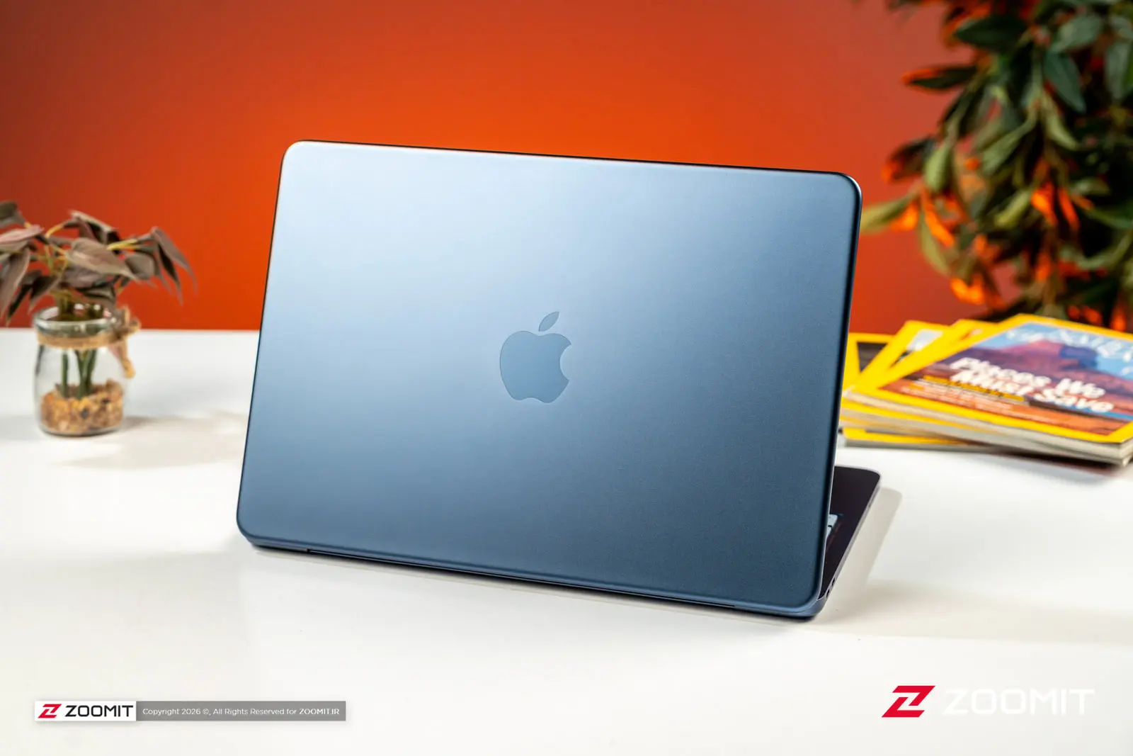 لپتاپ مکبوک نئو (MacBook Neo) با بدنه آبی متالیک روی میز